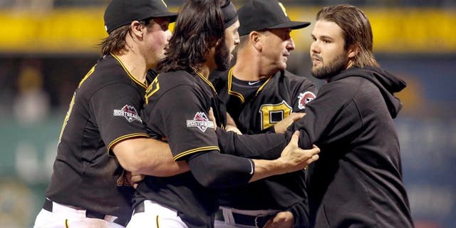Oct 7, 2015; Pittsburgh, PA, USA; Pittsburgh Pirates first baseman Sean Rodriguez (3) is held back by teammates during an altercation with the Chicago Cubs during the seventh inning in the National League Wild Card playoff baseball game at PNC Park. Rodriguez was ejected from the game. Mandatory Credit: Charles LeClaire-USA TODAY Sports