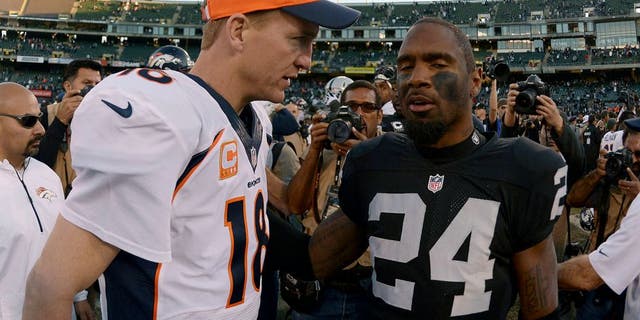 Dec 29, 2013; Oakland, CA, USA; Denver Broncos quarterback Peyton Manning (18) shakes hands with Oakland Raiders safety Charles Woodson (24) after the game at O.co Coliseum. The Broncos defeated the Raiders 34-14. Mandatory Credit: Kirby Lee-USA TODAY Sports