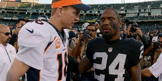 Dec 29, 2013; Oakland, CA, USA; Denver Broncos quarterback Peyton Manning (18) shakes hands with Oakland Raiders safety Charles Woodson (24) after the game at O.co Coliseum. The Broncos defeated the Raiders 34-14. Mandatory Credit: Kirby Lee-USA TODAY Sports