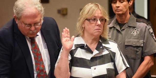 FILE - In this July 28, 2015 file photo, Joyce Mitchell raises her hand during a court appearance in Plattsburgh, N.Y. Mitchell, the former New York prison employee who helped two killers escape from a maximum-security prison in June, said in an interview that aired Monday, Sept. 14, on NBC's "Today" show that she was depressed at the time and the inmates took advantage of what she called her "weakness." (Rob Fountain/The Press-Republican via AP, Pool, File)