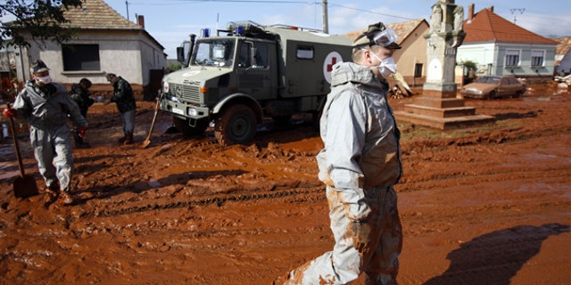 Oct. 7: A Hungarian soldier walks through a street flooded by toxic mud in Devecser, Hungary.