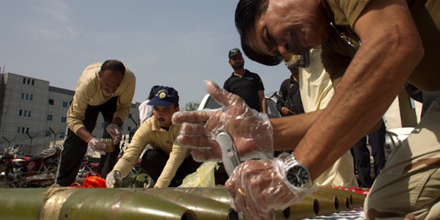 Oct. 8: Pakistani explosive experts defuse ammunition and suicide vests they recovered from a house in Islamabad, Pakistan.
