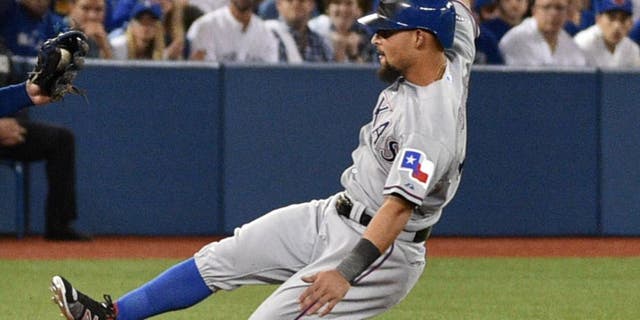 Oct 9, 2015; Toronto, Ontario, CAN; Texas Rangers second baseman Rougned Odor (12) slides into third base ahead of the tag by Toronto Blue Jays third baseman Josh Donaldson in the second inning in game two of the ALDS at Rogers Centre. Mandatory Credit: Nick Turchiaro-USA TODAY Sports