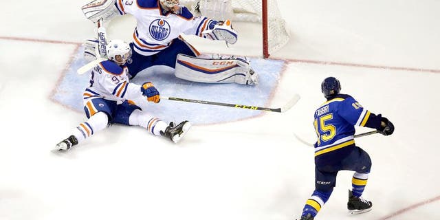 St. Louis Blues' Robby Fabbri, right, scores past Edmonton Oilers goalie Cam Talbot and Ryan Nugent-Hopkins, bottom left, during the third period of an NHL hockey game Thursday, Oct. 8, 2015, in St. Louis. The Blues won 3-1. (AP Photo/Jeff Roberson)