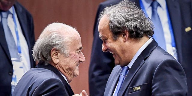 FIFA President Sepp Blatter (Foreground-L) shakes hands with UEFA president Michel Platini after being re-elected following a vote to decide on the FIFA presidency in Zurich on May 29, 2015. Sepp Blatter won the FIFA presidency for a fifth time after his challenger Prince Ali bin al Hussein withdrew just before a scheduled second round. AFP PHOTO / MICHAEL BUHOLZER (Photo credit should read MICHAEL BUHOLZER/AFP/Getty Images)
