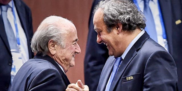 FIFA President Sepp Blatter (Foreground-L) shakes hands with UEFA president Michel Platini after being re-elected following a vote to decide on the FIFA presidency in Zurich on May 29, 2015. Sepp Blatter won the FIFA presidency for a fifth time after his challenger Prince Ali bin al Hussein withdrew just before a scheduled second round. AFP PHOTO / MICHAEL BUHOLZER (Photo credit should read MICHAEL BUHOLZER/AFP/Getty Images)