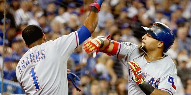 Rougned Odor #12 of the Texas Rangers celebrates with teammate Elvis Andrus #1 after scoring a solo home run against David Price #14 of the Toronto Blue Jays in the seventh inning during game one of the American League Division Series at Rogers Centre on October 8, 2015 in Toronto, Ontario, Canada. (Photo by Tom Szczerbowski/Getty Images)