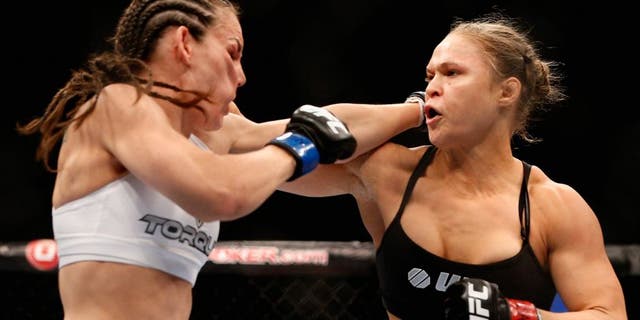 LAS VEGAS, NV - JULY 05: (R-L) UFC women's bantamweight champion Ronda Rousey punches Alexis Davis in their UFC women's bantamweight championship fight at UFC 175 inside the Mandalay Bay Events Center on July 5, 2014 in Las Vegas, Nevada. (Photo by Josh Hedges/Zuffa LLC/Zuffa LLC via Getty Images)