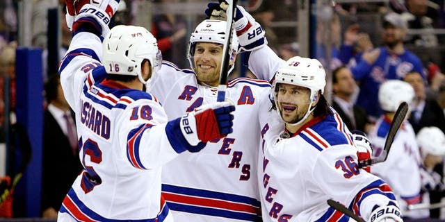 New York Rangers' Mats Zuccarello, right, celebrates his goal against the Columbus Blue Jackets with teammates Derick Brassard, left, and Dan Girardi during the third period of an NHL hockey game Friday, Oct. 9, 2015, in Columbus, Ohio. The Rangers beat the Blue Jackets 4-2. (AP Photo/Jay LaPrete)
