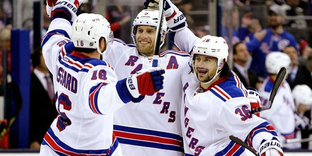 New York Rangers' Mats Zuccarello, right, celebrates his goal against the Columbus Blue Jackets with teammates Derick Brassard, left, and Dan Girardi during the third period of an NHL hockey game Friday, Oct. 9, 2015, in Columbus, Ohio. The Rangers beat the Blue Jackets 4-2. (AP Photo/Jay LaPrete)