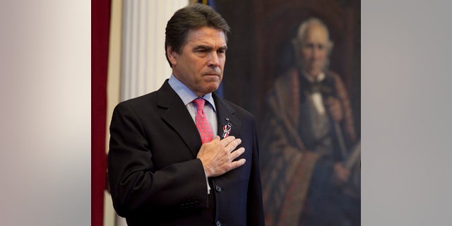 Texas Gov. Rick Perry with his hand over his heart during a joint session of the Texas Legislature to honor fallen Texas servicemen in the House Chamber on Saturday, May 28, 2011 in Austin. (AP)
