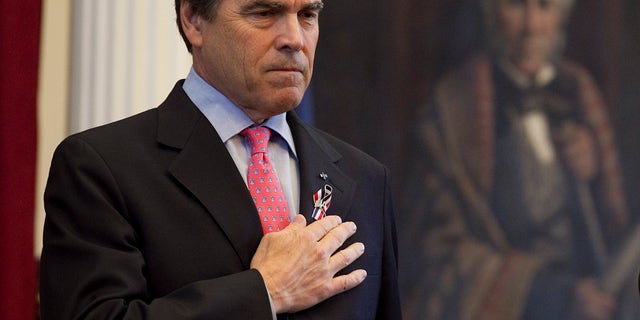 Texas Gov. Rick Perry with his hand over his heart during a joint session of the Texas Legislature to honor fallen Texas servicemen in the House Chamber on Saturday, May 28, 2011 in Austin. (AP)