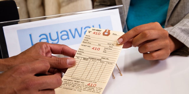 Shopper filling out layaway tag at checkout counter