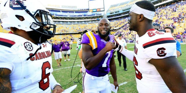 Oct 10, 2015; Baton Rouge, LA, USA; LSU Tigers running back Leonard Fournette (7) talks to South Carolina Gamecocks tight end Kevin Crosby (86) and safety Chris Moody (6) following road game at Tiger Stadium. LSU defeated South Carolina 45-24. Mandatory Credit: Derick E. Hingle-USA TODAY Sports