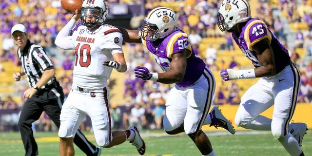 Oct 10, 2015; Baton Rouge, LA, USA; South Carolina Gamecocks quarterback Perry Orth (10) is pressured by LSU Tigers defensive end Lewis Neal (92) during the first quarter of a game at Tiger Stadium. Mandatory Credit: Derick E. Hingle-USA TODAY Sports