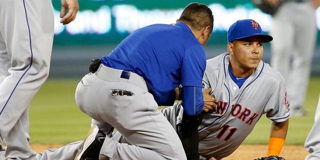 LOS ANGELES, CA - OCTOBER 10: Ruben Tejada #11 of the New York Mets is given medial attention on the field after sustaining an injury in the seventh inning on slide by Chase Utley #26 of the Los Angeles Dodgers in game two of the National League Division Series at Dodger Stadium on October 10, 2015 in Los Angeles, California. (Photo by Sean M. Haffey/Getty Images)