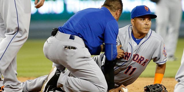 LOS ANGELES, CA - OCTOBER 10: Ruben Tejada #11 of the New York Mets is given medial attention on the field after sustaining an injury in the seventh inning on slide by Chase Utley #26 of the Los Angeles Dodgers in game two of the National League Division Series at Dodger Stadium on October 10, 2015 in Los Angeles, California. (Photo by Sean M. Haffey/Getty Images)