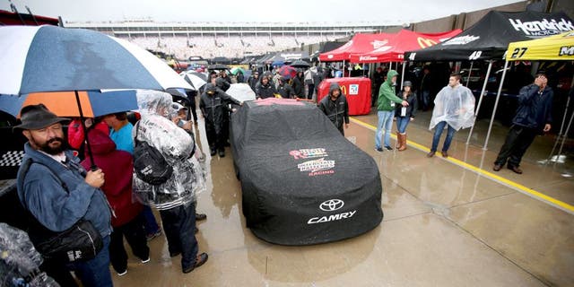 CHARLOTTE, NC - OCTOBER 10: The #18 M&M's Pretty In Pink Foundation Toyota of Kyle Busch sits covered in the rain prior to the NASCAR Sprint Cup Series Bank of America 500 at Charlotte Motor Speedway on October 10, 2015 in Charlotte, North Carolina. (Photo by Chris Graythen/NASCAR via Getty Images)