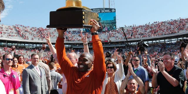 Oct 10, 2015; Dallas, TX, USA; Texas Longhorns head coach Charlie Strong celebrates with the golden hat trophy after a victory against the Oklahoma Sooners during Red River rivalry at Cotton Bowl Stadium. Texas beat Oklahoma 24-17. Mandatory Credit: Matthew Emmons-USA TODAY Sports