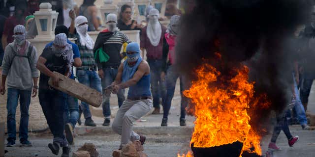 Oct. 10, 2015: Palestinians improvise a barricade during clashes with Israeli troops near Ramallah, West Bank.