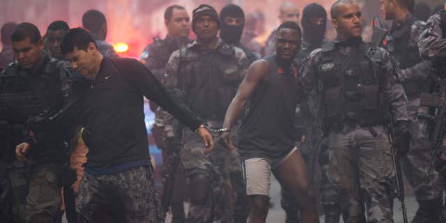 Oct. 10, 2016: Police move a couple of handcuffed, recently detained men at Pavao Pavaozinho slum during a police operation in Rio de Janeiro, Brazil.