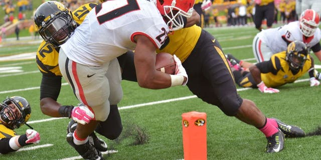 Oct 11, 2014; Columbia, MO, USA; Georgia Bulldogs running back Nick Chubb (27) scores a touchdown as Missouri Tigers linebacker Darvin Ruise (12) and safety Braylon Webb (9) make the tackle during the second half at Faurot Field. Georgia won 34-0. Mandatory Credit: Denny Medley-USA TODAY Sports