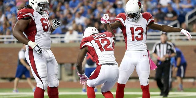DETROIT MI - OCTOBER 11: John Brown of the Arizona Cardinals celebrates his second-quarter touchdown against the Detroit Lions with teammates Jaron Brown and Jonathan Cooper on October 11, 2015 at Ford Field in Detroit, Michigan. (Photo by Leon Halip/Getty Images)
