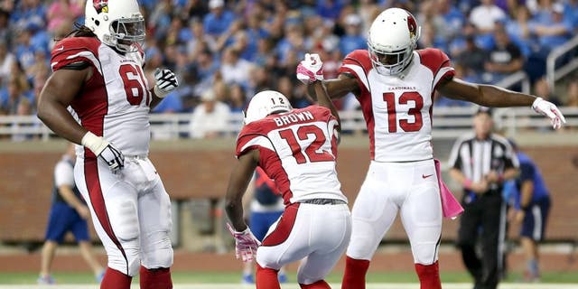 DETROIT MI - OCTOBER 11: John Brown of the Arizona Cardinals celebrates his second-quarter touchdown against the Detroit Lions with teammates Jaron Brown and Jonathan Cooper on October 11, 2015 at Ford Field in Detroit, Michigan. (Photo by Leon Halip/Getty Images)