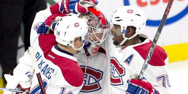 Montreal Canadiens defenseman P.K. Subban, right, and center Tomas Plekanec congratulate goalie Mike Condon as the Canadiens defeat the Ottawa Senators in an NHL hockey game, Sunday, Oct. 11, 2015 in Ottawa, Ontario. (Adrian Wyld/The Canadian Press via AP) MANDATORY CREDIT