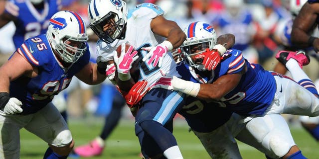 Oct 11, 2015; Nashville, TN, USA; Tennessee Titans running back Bishop Sankey (20) is tackled by Buffalo Bills defensive end Jerry Hughes (55) and defensive tackle Kyle Williams (95) during the second half at Nissan Stadium. The Bills won 14-13. Mandatory Credit: Christopher Hanewinckel-USA TODAY Sports