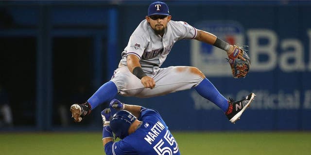 TORONTO, ON- OCTOBER 9: Joey Gallo leaps over Russell Martin turning a double play. The Toronto Blue Jays and Texas Rangers play game two of the MLB American League Division Series . at Rogers Centre in Toronto. October 9, 2015. (Steve Russell/Toronto Star via Getty Images)