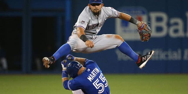 TORONTO, ON- OCTOBER 9: Joey Gallo leaps over Russell Martin turning a double play. The Toronto Blue Jays and Texas Rangers play game two of the MLB American League Division Series . at Rogers Centre in Toronto. October 9, 2015. (Steve Russell/Toronto Star via Getty Images)