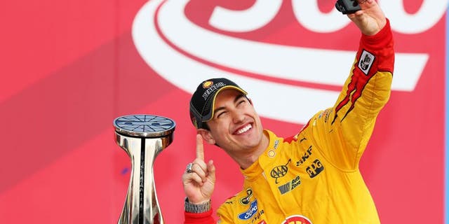 CHARLOTTE, NC - OCTOBER 11: Joey Logano, driver of the #22 Shell Pennzoil Ford, takes a 'selfie' in Victory Lane after winning the NASCAR Sprint Cup Series Bank of America 500 at Charlotte Motor Speedway on October 11, 2015 in Charlotte, North Carolina. (Photo by Chris Graythen/NASCAR via Getty Images)