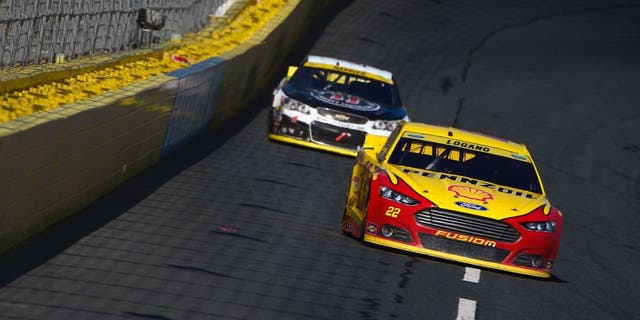 CHARLOTTE, NC - OCTOBER 11: Joey Logano, driver of the #22 Shell Pennzoil Ford, leads Kevin Harvick, driver of the #4 Jimmy John's/Budweiser Chevrolet, during the NASCAR Sprint Cup Series Bank of America 500 at Charlotte Motor Speedway on October 11, 2015 in Charlotte, North Carolina. (Photo by Robert Laberge/NASCAR via Getty Images)