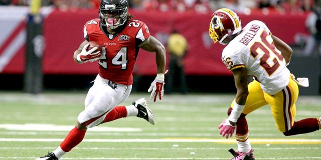 Oct 11, 2015; Atlanta, GA, USA; Atlanta Falcons running back Devonta Freeman (24) runs against Washington Redskins cornerback Bashaud Breeland (26) in the third quarter of their game at the Georgia Dome. The Falcons won 25-19 in overtime. Mandatory Credit: Jason Getz-USA TODAY Sports