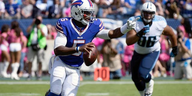 NASHVILLE, TN - OCTOBER 11: Quarterback Tyrod Taylor #5 of the Buffalo Bills rushes out of the reach of Al Woods #96 of the Tennessee Titans during the first half of a game at Nissan Stadium on October 11, 2015 in Nashville, Tennessee. (Photo by Frederick Breedon/Getty Images)