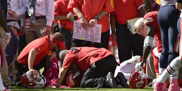 KANSAS CITY, MO - OCTOBER 11: Kansas City Chiefs training staff attends to an injury for Jamaal Charles #25 of the Kansas City Chiefs after a run with head coach Andy Reid of the Kansas City Chiefs overlooking at Arrowhead Stadium during the game against the Chicago Bears on October 11, 2015 in Kansas City, Missouri. (Photo by Peter Aiken/Getty Images)