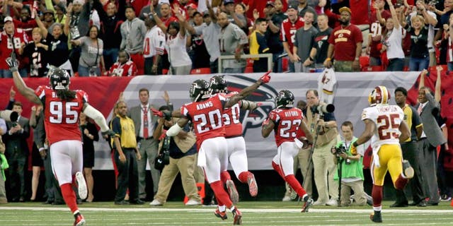 Oct 11, 2015; Atlanta, GA, USA; Atlanta Falcons defensive tackle Jonathan Babineaux (95) and defensive back Phillip Adams (20) celebrate as cornerback Robert Alford (23, right) returns an interception for a touchdown to win the game in overtime against the Washington Redskins at the Georgia Dome. The Falcons won 25-19 in overtime. Mandatory Credit: Jason Getz-USA TODAY Sports