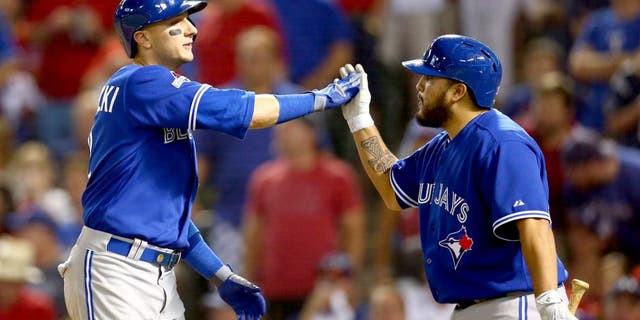 ARLINGTON, TX - OCTOBER 11: Troy Tulowitzki #2 of the Toronto Blue Jays celebrates with his teammate Dioner Navarro #30 after hitting a three run home run against Chi Chi Gonzalez #21 of the Texas Rangers in the sixth inning during game three of the American League Division Series on October 11, 2015 in Arlington, Texas. (Photo by Ronald Martinez/Getty Images)