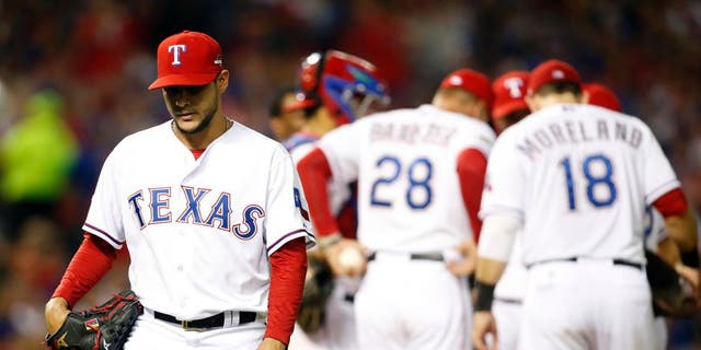 Oct 11, 2015; Arlington, TX, USA; Texas Rangers starting pitcher Martin Perez (left) walks to the dugout after being relieved against the Toronto Blue Jays in the 6th inning in game three of the ALDS at Globe Life Park in Arlington. Mandatory Credit: Tim Heitman-USA TODAY Sports