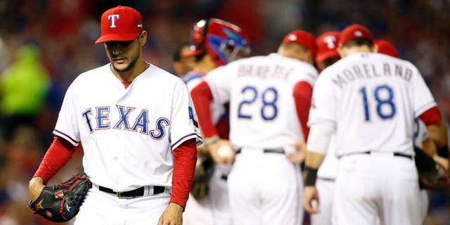 Oct 11, 2015; Arlington, TX, USA; Texas Rangers starting pitcher Martin Perez (left) walks to the dugout after being relieved against the Toronto Blue Jays in the 6th inning in game three of the ALDS at Globe Life Park in Arlington. Mandatory Credit: Tim Heitman-USA TODAY Sports