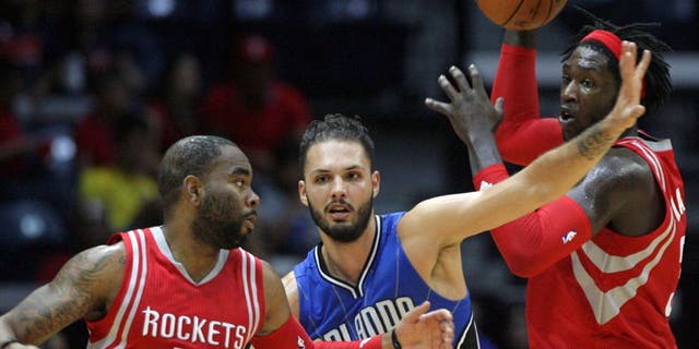Houston Rockets Montrezl Harrell, right, looks for open teammate Marcus Thorton (10), as Orlando Magic Evan Fournier defends during the second half of a preseason NBA basketball game Sunday, Oct. 11, 2015, in Hidalgo, Texas. (AP Photo/Delcia Lopez)