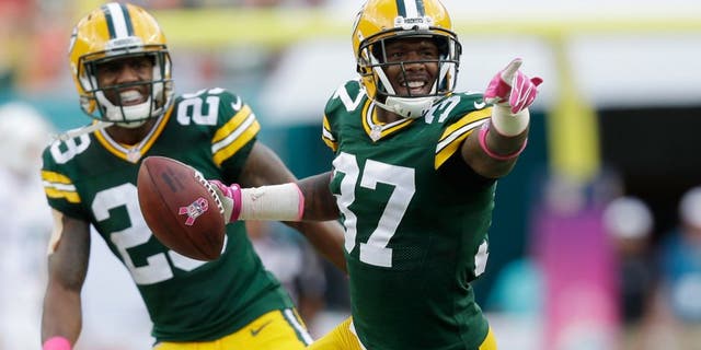 Green Bay Packers cornerback Sam Shields (37) points to the sidelines after intercepting a ball intended for Miami Dolphins wide receiver Brian Hartline (82) during the first half of an NFL football game, Sunday, Oct. 12, 2014, in Miami Gardens, Fla. In the background is Green Bay Packers cornerback Casey Hayward (29). (AP Photo/Wilfredo Lee)