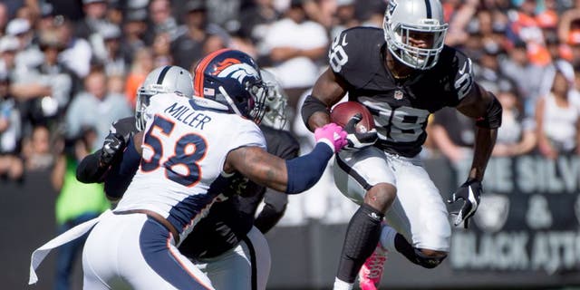 October 11, 2015; Oakland, CA, USA; Oakland Raiders running back Latavius Murray (28) runs with the football against Denver Broncos outside linebacker Von Miller (58) during the first quarter at O.co Coliseum. Mandatory Credit: Kyle Terada-USA TODAY Sports