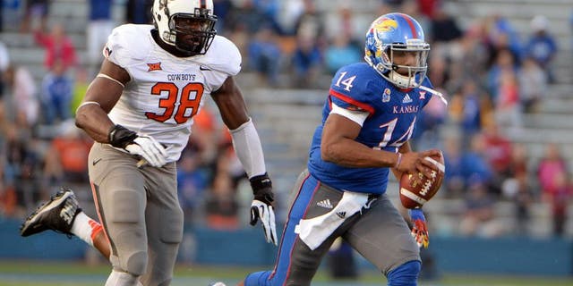 Oct 11, 2014; Lawrence, KS, USA; Kansas Jayhawks quarterback Michael Cummings (14) is chased by Oklahoma State Cowboys defensive end Emmanuel Ogbah (38) in the second half at Memorial Stadium. Oklahoma State won the game 27-20. Mandatory Credit: John Rieger-USA TODAY Sports