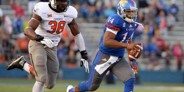 Oct 11, 2014; Lawrence, KS, USA; Kansas Jayhawks quarterback Michael Cummings (14) is chased by Oklahoma State Cowboys defensive end Emmanuel Ogbah (38) in the second half at Memorial Stadium. Oklahoma State won the game 27-20. Mandatory Credit: John Rieger-USA TODAY Sports