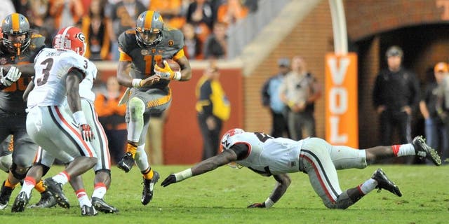 Oct 10, 2015; Knoxville, TN, USA; Tennessee Volunteers quarterback Joshua Dobbs (11) rushes against Georgia Bulldogs linebacker Tim Kimbrough (42) and Bulldogs linebacker Roquan Smith (3) during the second half at Neyland Stadium. Tennessee won 38-31. Mandatory Credit: Jim Brown-USA TODAY Sports