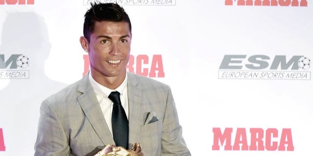 Real Madrid's Portuguese forward Cristiano Ronaldo poses with his fourth European Golden Shoe in Madrid, on October 13, 2015. Cristiano, who ended the season with 48 goals from 35 appearances, won the Golden Shoe in 2008 while he was at Manchester United, in 2011 with Real Madrid and shared it with Luis Suarez last year. AFP PHOTO / JAVIER SORIANO (Photo credit should read JAVIER SORIANO/AFP/Getty Images)