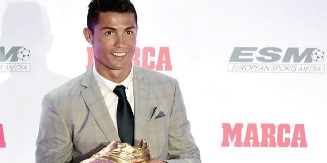 Real Madrid's Portuguese forward Cristiano Ronaldo poses with his fourth European Golden Shoe in Madrid, on October 13, 2015. Cristiano, who ended the season with 48 goals from 35 appearances, won the Golden Shoe in 2008 while he was at Manchester United, in 2011 with Real Madrid and shared it with Luis Suarez last year. AFP PHOTO / JAVIER SORIANO (Photo credit should read JAVIER SORIANO/AFP/Getty Images)
