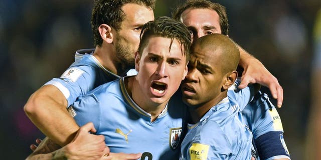 Uruguay's forward Diego Rolan (R, front) celebrates with teammates Jose Maria Gimenez (C), Christian Stuani (L) and Diego Godin after scoring against Colombia during their Russia 2018 FIFA World Cup South American Qualifiers football match, at the Estadio Centenario stadium in Montevideo, on October 13, 2015. AFP PHOTO / PABLO PORCIUNCULA (Photo credit should read PABLO PORCIUNCULA/AFP/Getty Images)